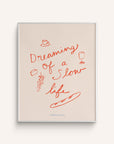 This mini art print features the phrase “Dreaming of a Slow Life” playfully surrounded by wine, cheese, grapes and a baguette painted in red on a white background.